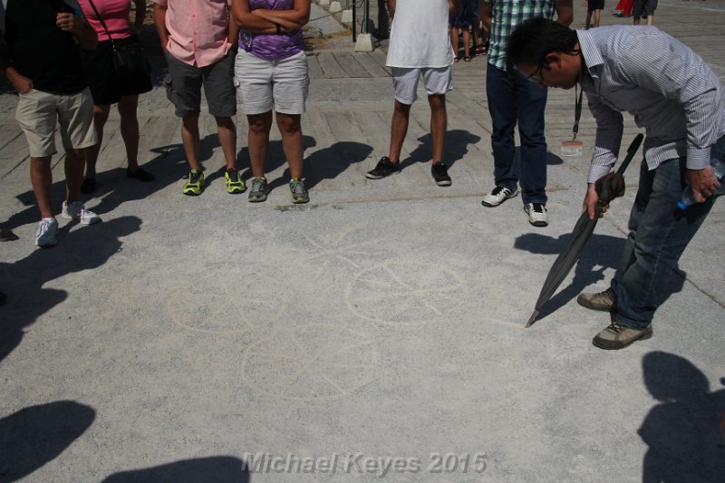 IMG_5296.JPG - Greek letters for fish also stood for Jesus Christ Son of God.  Our guide demonstrated how the early Christians had taken those Greek letters, laid them on top of each other and created a secret symbol that resembled a wheel with spokes. This symbol was carved into some of the marble stones and helped to identify the path to safe homes for Christians being persecuted. 