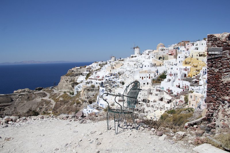 IMG_7785.JPG - Chair against the Back Trop of Oia. 